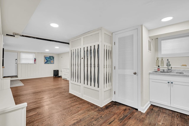 interior space featuring recessed lighting, a sink, and dark wood finished floors