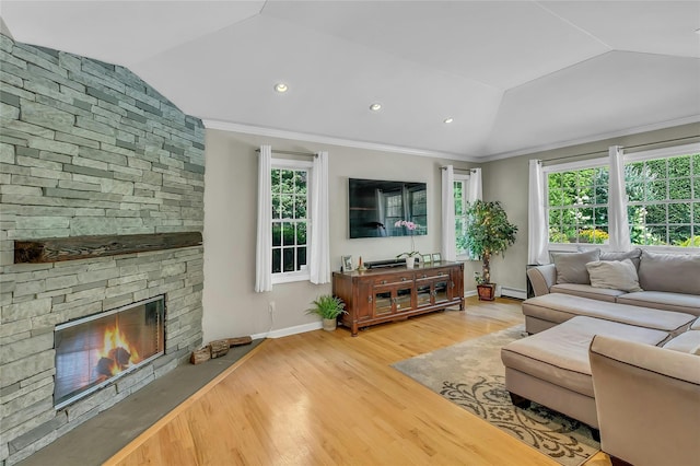 living area featuring a baseboard radiator, lofted ceiling, and a wealth of natural light