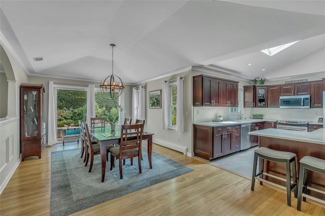 kitchen with light countertops, vaulted ceiling with skylight, and appliances with stainless steel finishes