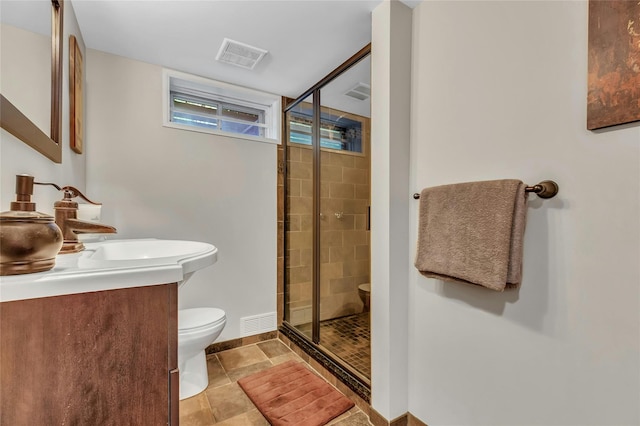 bathroom with a shower stall, vanity, baseboards, toilet, and visible vents