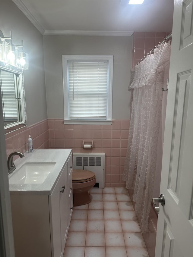 bathroom with toilet, tile walls, plenty of natural light, radiator heating unit, and vanity