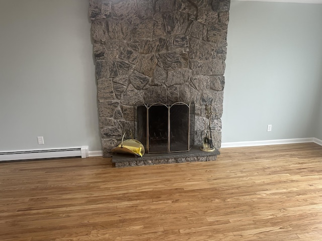 room details with a fireplace, wood finished floors, a baseboard radiator, and baseboards