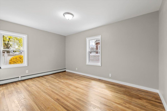 spare room featuring light wood-style floors, baseboards, and baseboard heating