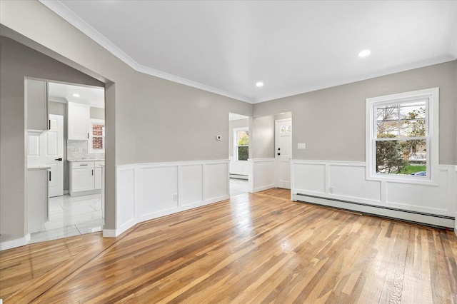 spare room with wainscoting, light wood-style floors, recessed lighting, a baseboard radiator, and ornamental molding