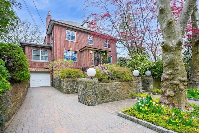 5235 Netherland Ave, Bronx, NY 10471 - american foursquare style home with brick siding, a chimney, a garage, and decorative driveway