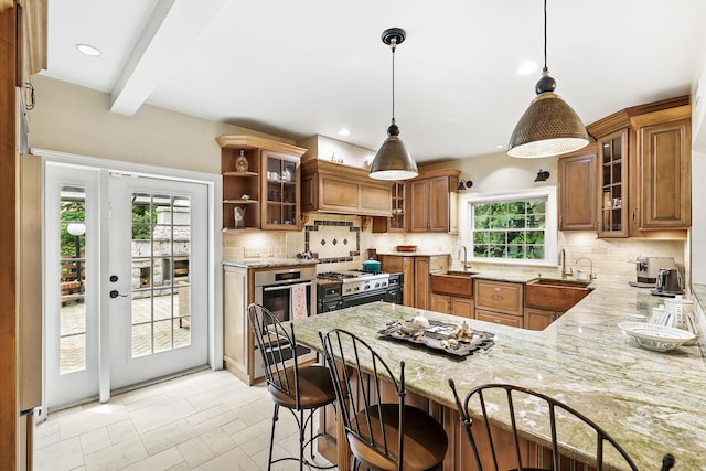 5235 Netherland Ave, Bronx, NY 10471 - kitchen featuring range with gas stovetop, a sink, brown cabinets, light stone countertops, and beamed ceiling
