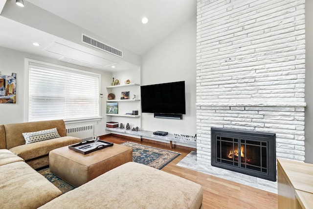 5235 Netherland Ave, Bronx, NY 10471 - living room with radiator heating unit, wood finished floors, a stone fireplace, recessed lighting, and lofted ceiling