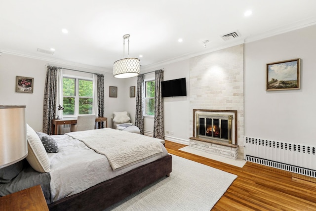 5235 Netherland Ave, Bronx, NY 10471 - bedroom featuring radiator, wood finished floors, a fireplace, ornamental molding, and recessed lighting