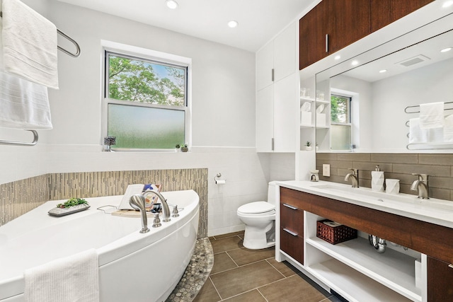 5235 Netherland Ave, Bronx, NY 10471 - bathroom featuring a bath, vanity, toilet, tile patterned flooring, and tile walls