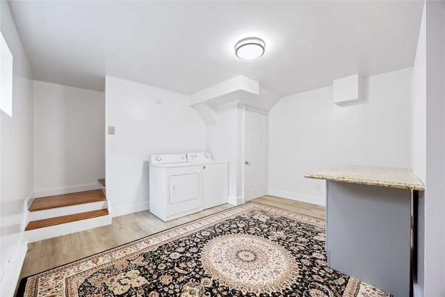 laundry room featuring washing machine and dryer, laundry area, baseboards, and light wood-style floors
