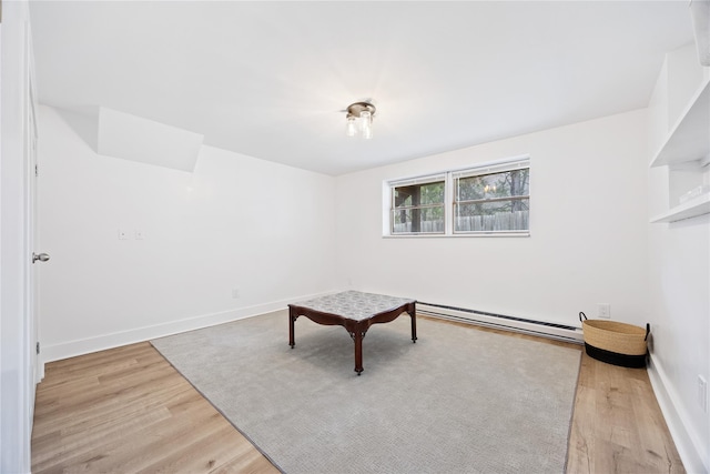 unfurnished room with light wood-style flooring, baseboards, and a baseboard radiator