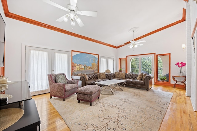 living room with light wood finished floors, ornamental molding, high vaulted ceiling, and ceiling fan