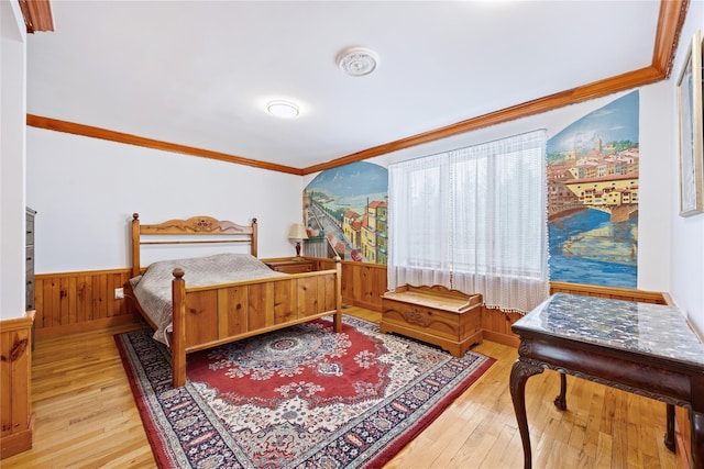bedroom with wood walls, ornamental molding, a wainscoted wall, and hardwood / wood-style floors