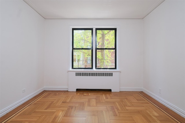 spare room featuring radiator, ornamental molding, and baseboards