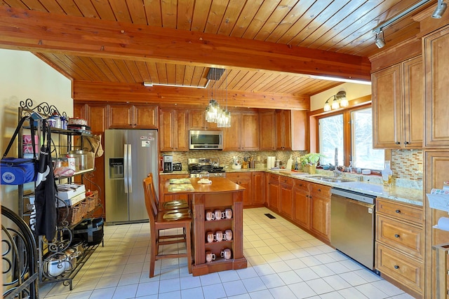 kitchen featuring light tile patterned flooring, stainless steel appliances, light countertops, backsplash, and beam ceiling