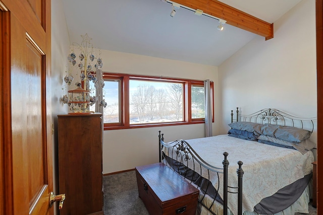 bedroom featuring track lighting, lofted ceiling with beams, baseboards, and carpet flooring