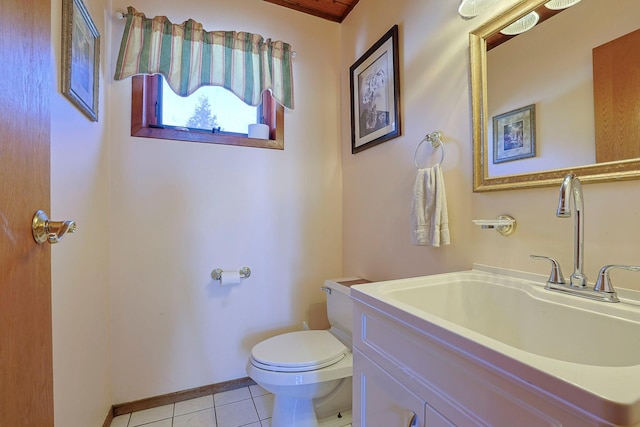 half bathroom with toilet, vanity, tile patterned floors, and baseboards