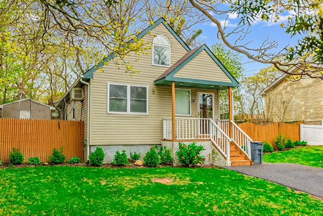 bungalow-style home featuring a front lawn and fence