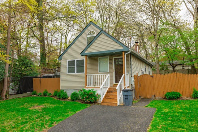 bungalow-style home with fence and a front yard