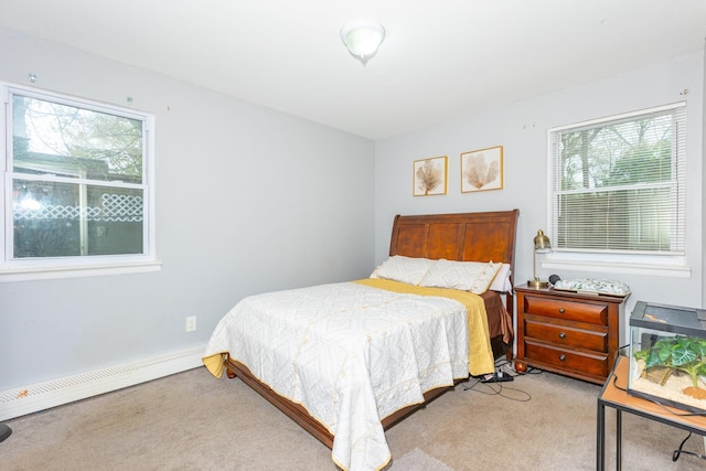 bedroom with light colored carpet and a baseboard heating unit