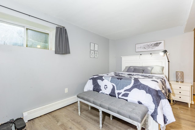 bedroom with baseboards, a baseboard radiator, and wood finished floors