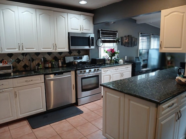 kitchen featuring white cabinetry, appliances with stainless steel finishes, a healthy amount of sunlight, and tasteful backsplash