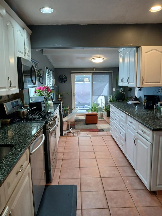 kitchen with recessed lighting, dark stone counters, white cabinetry, appliances with stainless steel finishes, and light tile patterned floors