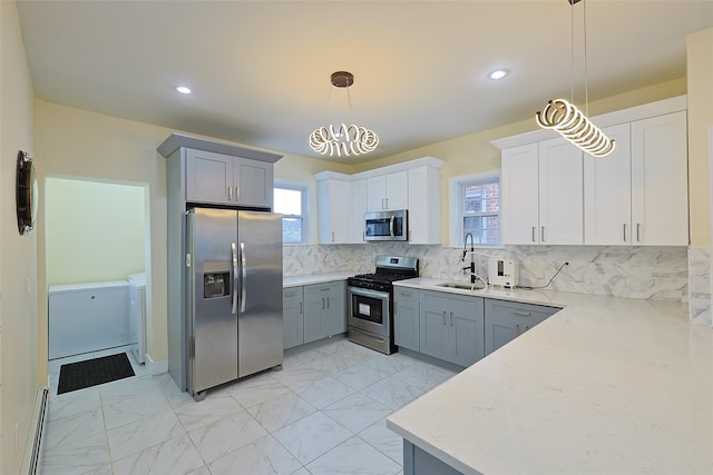 191-68 115th Rd, Saint Albans, NY 11412 - kitchen featuring stainless steel appliances, independent washer and dryer, a sink, decorative backsplash, and light marble finish floors