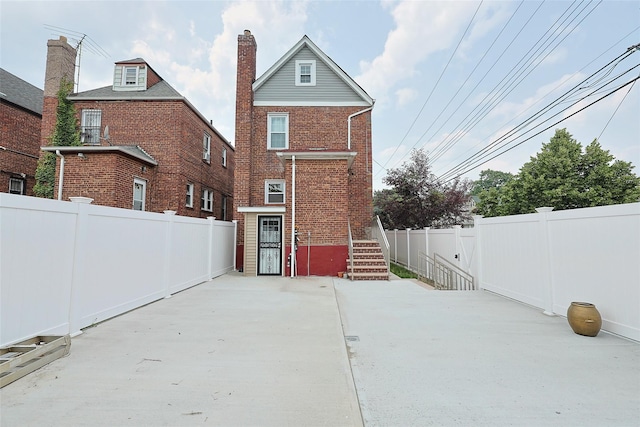 191-68 115th Rd, Saint Albans, NY 11412 - rear view of house featuring brick siding, a chimney, a fenced backyard, and a patio