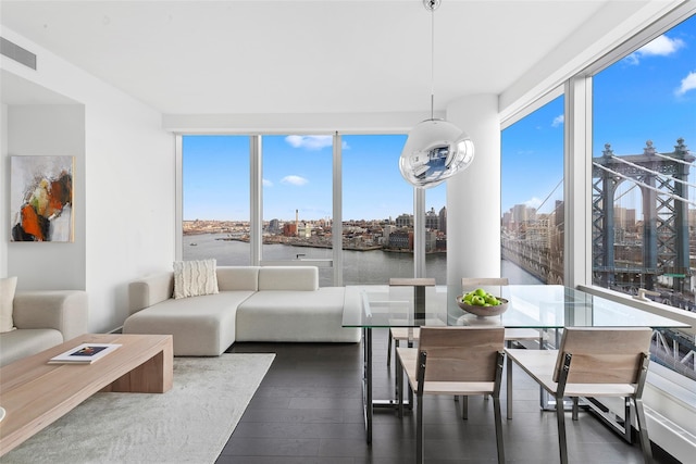 sunroom / solarium with a view of city, visible vents, a healthy amount of sunlight, and a water view