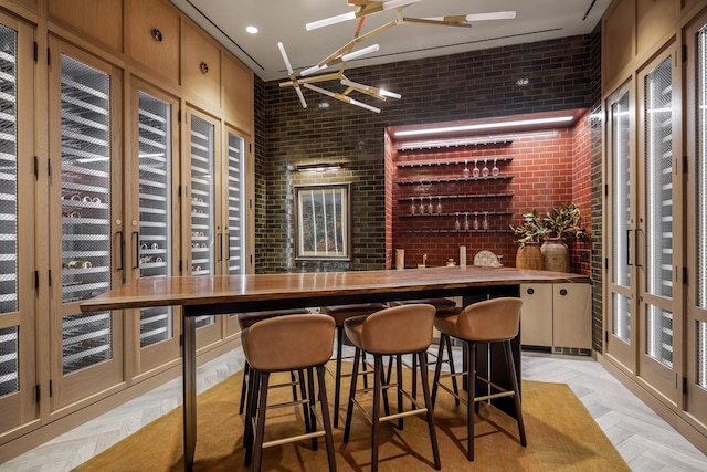 bar with a ceiling fan and brick wall