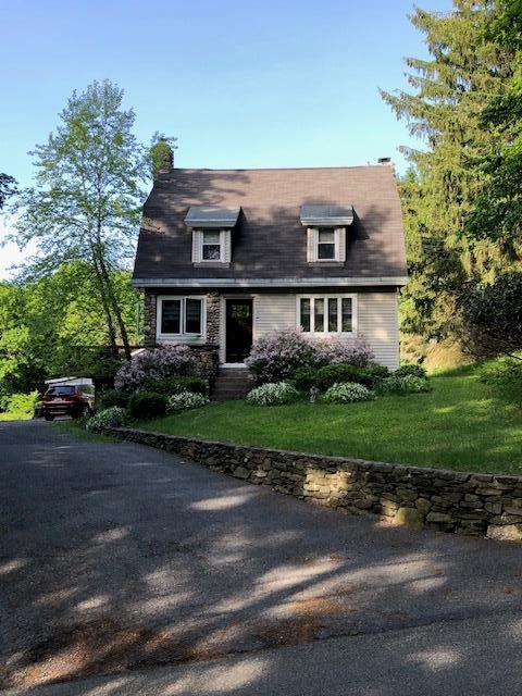 new england style home featuring a front lawn