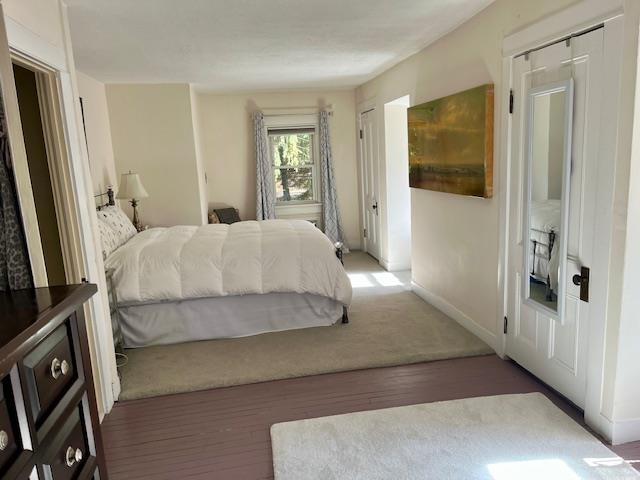 bedroom featuring wood finished floors and baseboards