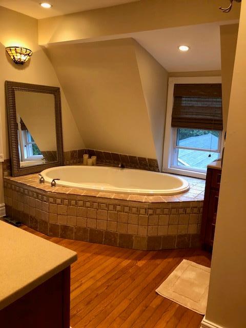 bathroom with a bath and wood finished floors