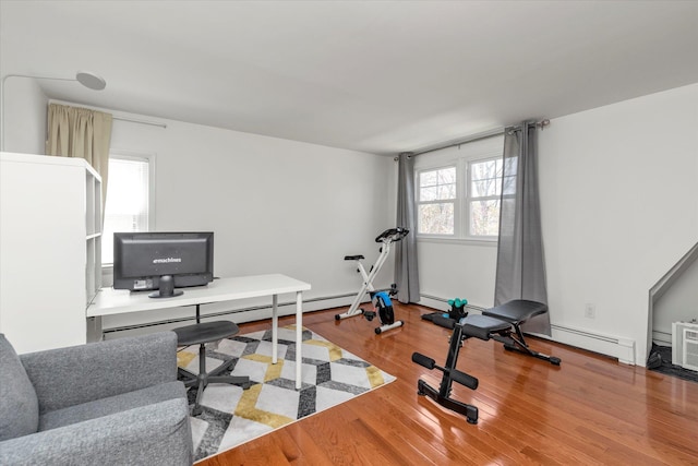 workout area featuring a baseboard heating unit and wood finished floors