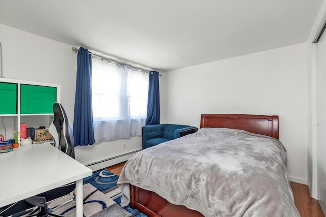 bedroom featuring a baseboard radiator and wood finished floors