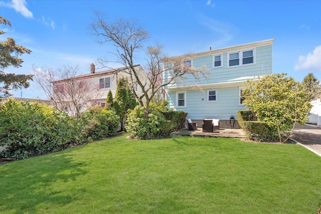 back of property with a patio and a yard