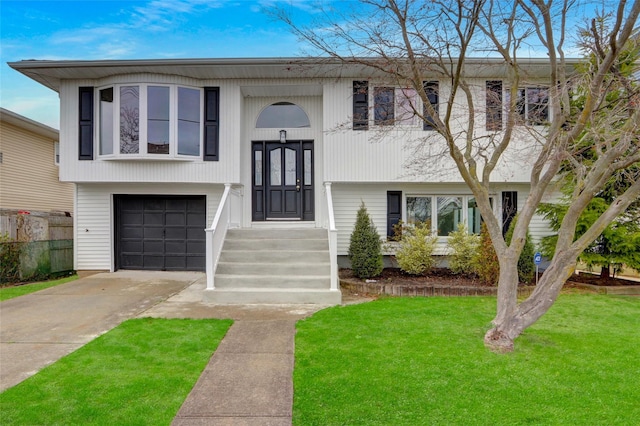 split foyer home featuring concrete driveway, a garage, and a front lawn