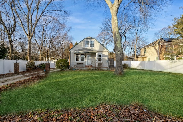 view of front of house featuring a porch, a fenced backyard, a chimney, and a front yard