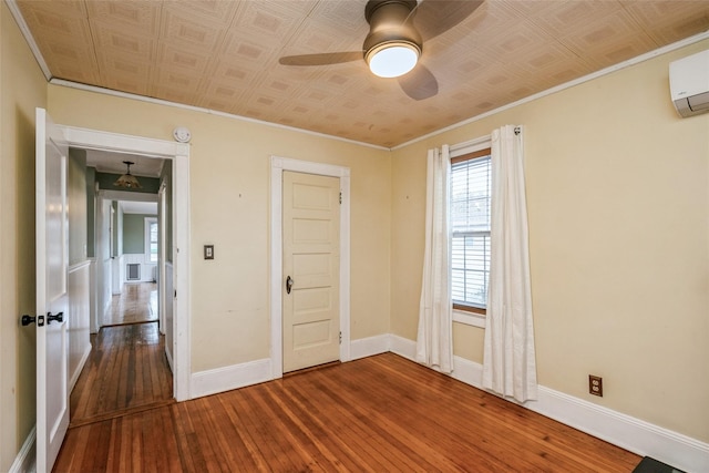 spare room featuring wood-type flooring, baseboards, ornamental molding, and an ornate ceiling