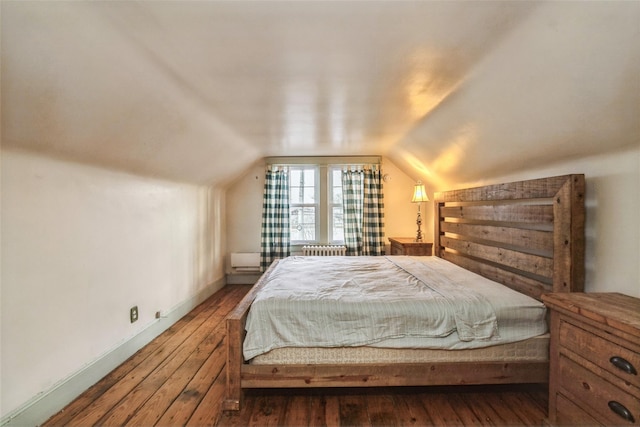 bedroom with lofted ceiling, hardwood / wood-style flooring, and baseboards