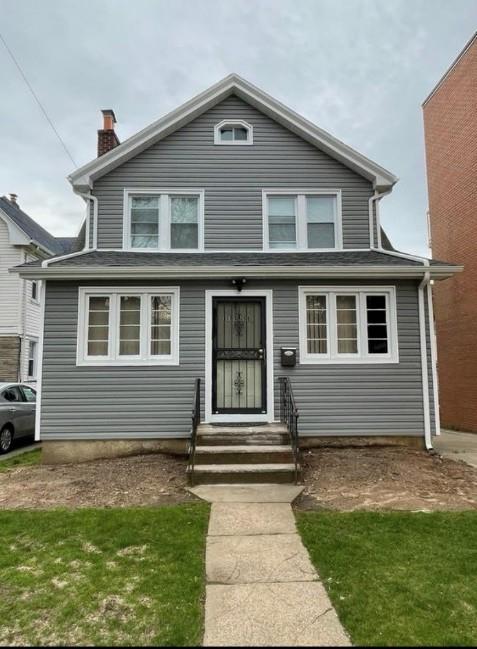 view of front facade featuring entry steps and a chimney