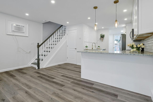286 9th St, Verplanck, NY 10596 - kitchen featuring refrigerator, light stone counters, wood finished floors, a wall unit AC, and stainless steel microwave