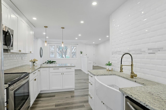 286 9th St, Verplanck, NY 10596 - kitchen featuring appliances with stainless steel finishes, a sink, recessed lighting, wood finished floors, and backsplash