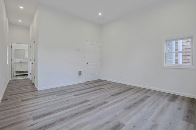 286 9th St, Verplanck, NY 10596 - empty room featuring light wood-type flooring, recessed lighting, baseboards, and a towering ceiling
