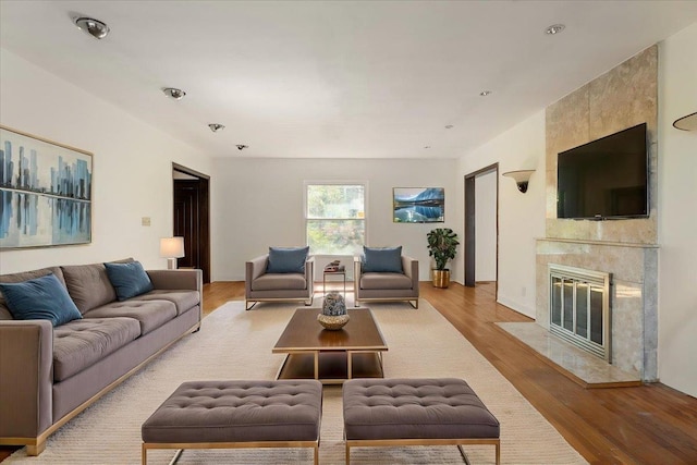 living area with light wood-style floors and a high end fireplace