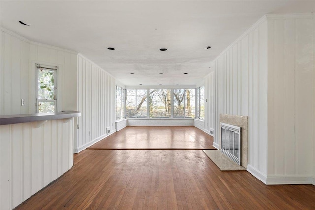 unfurnished living room with hardwood / wood-style flooring, a wealth of natural light, and a fireplace