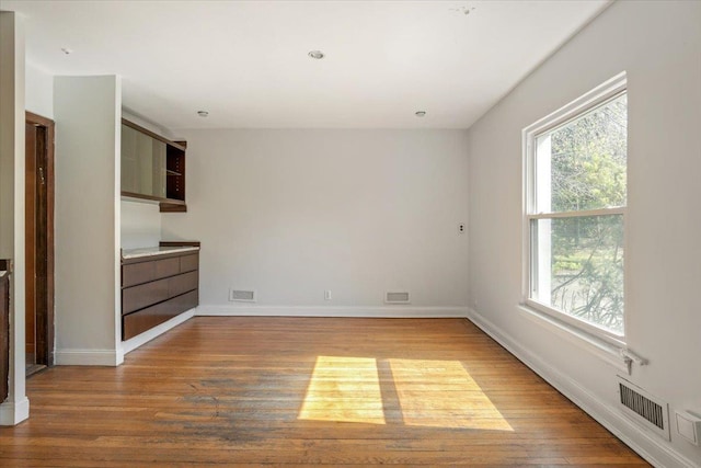 interior space featuring a healthy amount of sunlight, wood finished floors, and visible vents