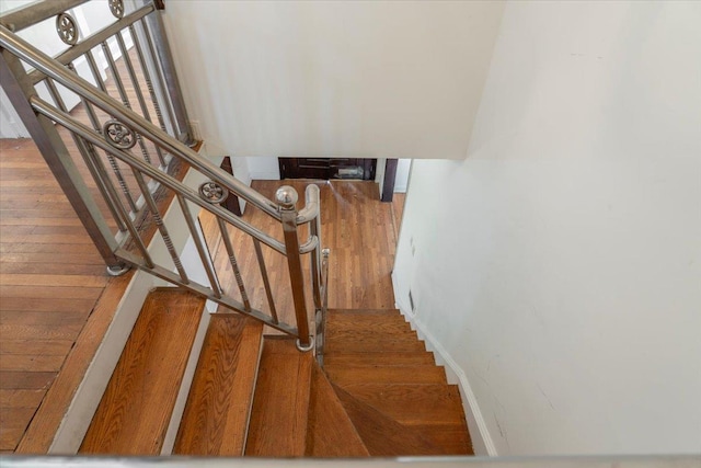 stairway featuring wood finished floors and baseboards