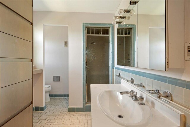 full bathroom with backsplash, toilet, vanity, baseboards, and a stall shower